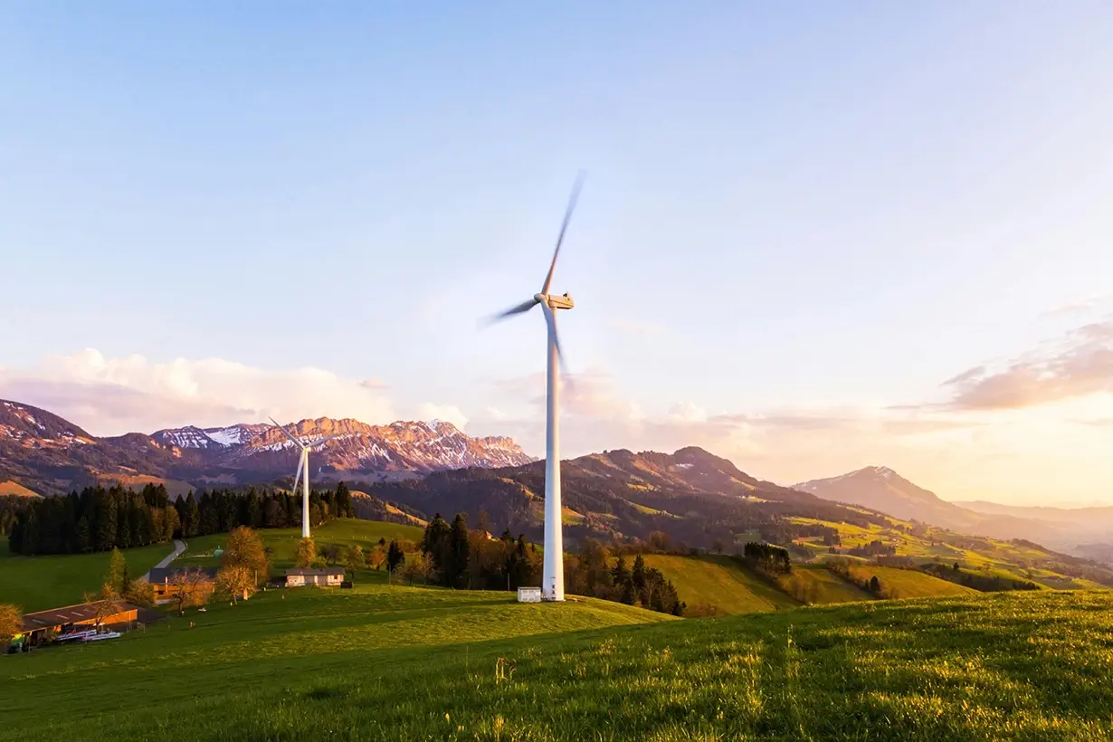 Éolienne dans un paysage de montagne au coucher du soleil